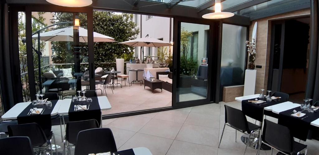 ゾーラ・プレドーザにあるContinental Urban Art Hotelのテーブルと椅子、パティオ付きのレストラン