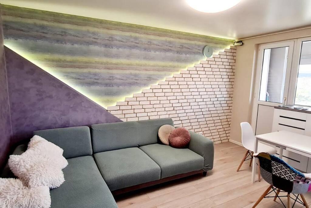 salon z kanapą i ceglaną ścianą w obiekcie 2 rooms A&B Center Panorama w Jassach