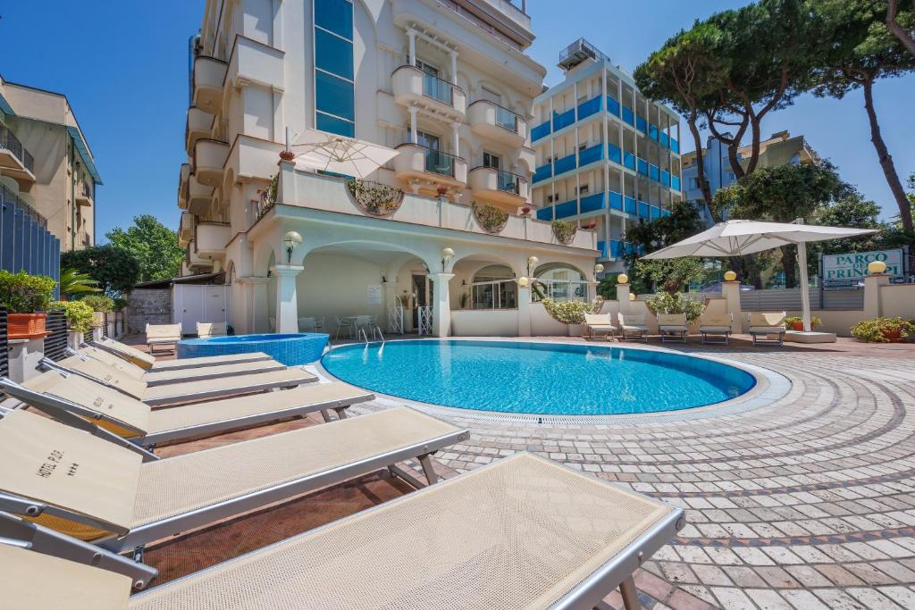 ein Schwimmbad vor einem Gebäude in der Unterkunft Parco dei Principi Boutique Hotel in Rimini