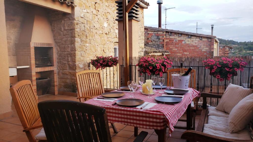 einen Tisch mit einem roten und weißen Tischtuch auf einer Terrasse in der Unterkunft ESPECTACULAR CASA RURAL CA L'ESQUERRÉ in Cerviá