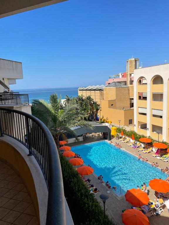 vistas a una piscina con sombrillas naranjas y al océano en appartamento vista mare da MARY en Gallipoli