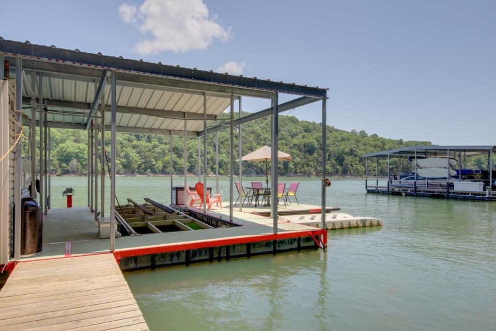 a dock with a table and chairs on the water at Lakefront LaFollette Home with Private Boat Slip! in Alder