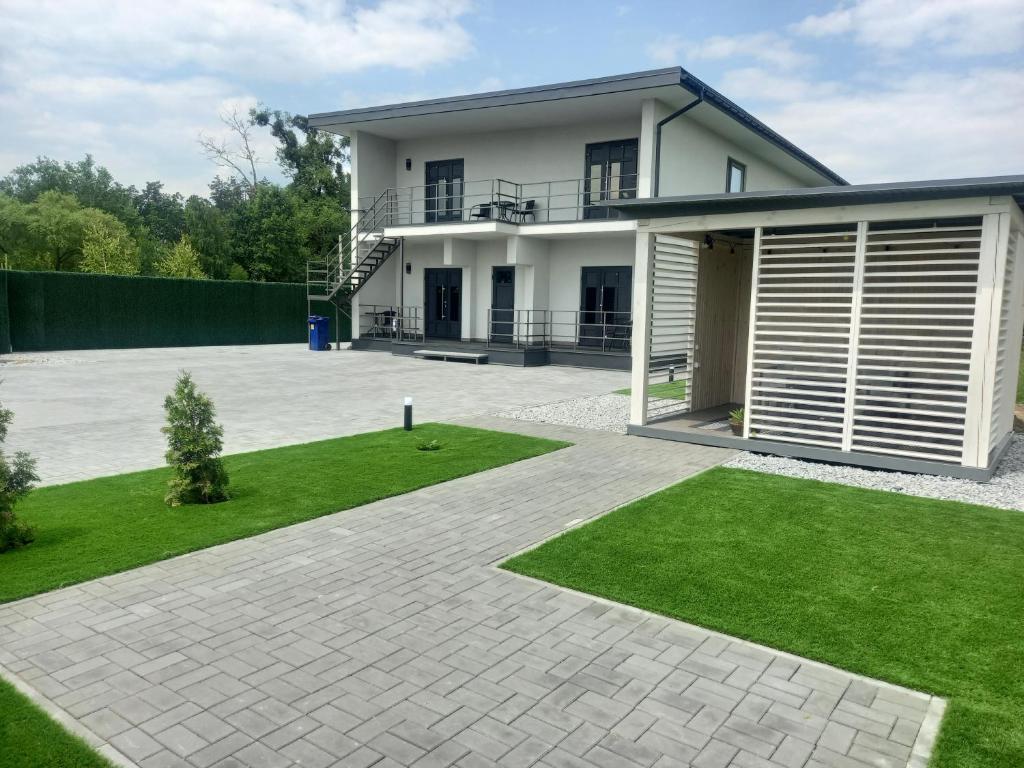 a large white house with a lawn in front of it at apartments Best time to rest in Glubochitsa