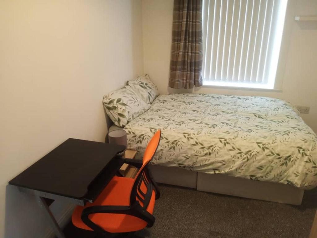 Dormitorio pequeño con cama, escritorio y silla en Ensuite Double-bed (H1) close to Burnley city centre en Burnley