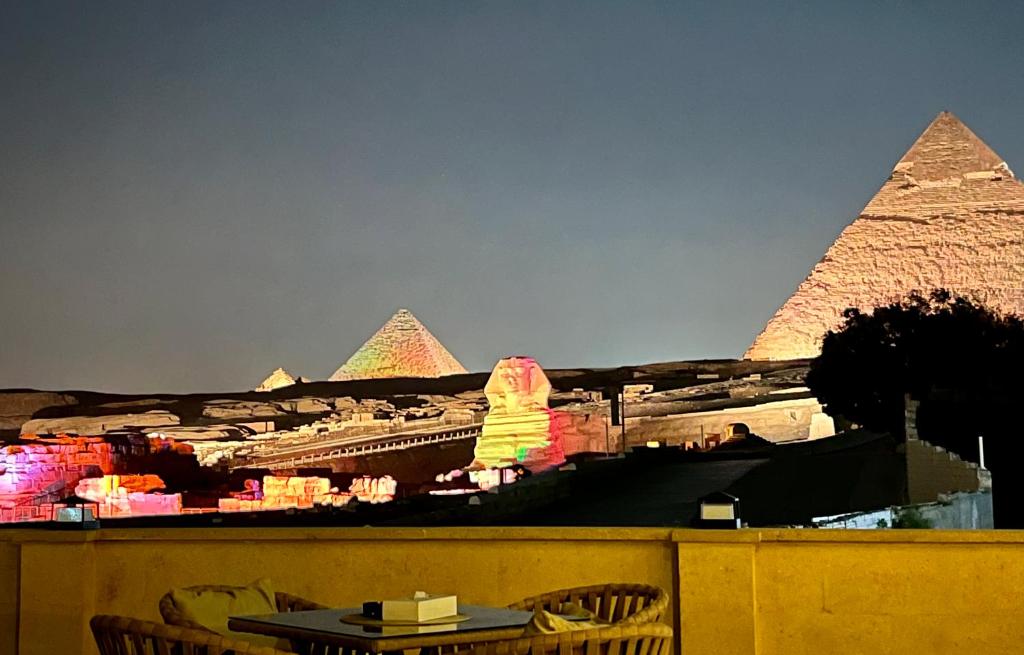 een zicht op de piramides van Giza 's nachts bij The Gate Hotel Front Pyramids & Sphinx View in Caïro