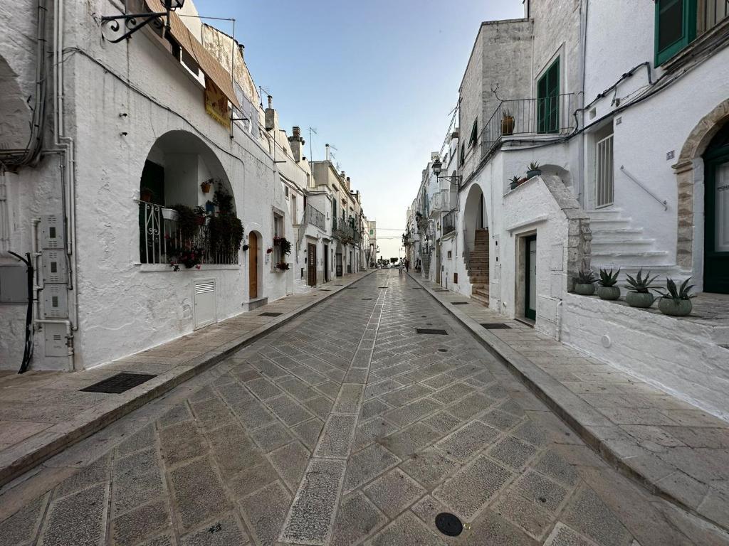 eine leere Straße in einer Gasse mit weißen Gebäuden in der Unterkunft Casa Pietra Viva in Cisternino