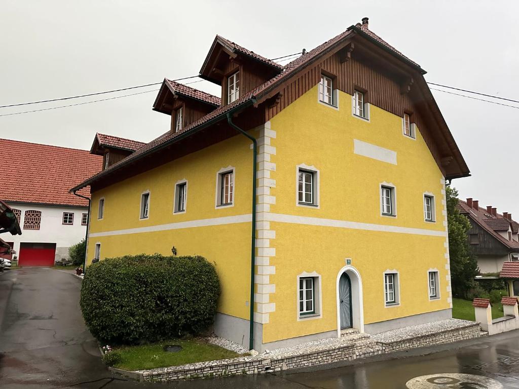 una casa amarilla con techo marrón en Michlbauer - Kaufmann Aloisia en Sankt Peter ob Judenburg