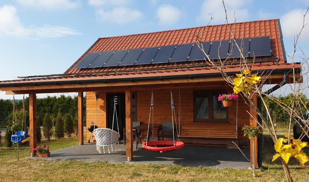 uma casa com painéis solares no telhado em Słowińskie Widoki domek Natura, noclegi Smołdziński Las em Smoldziński Las