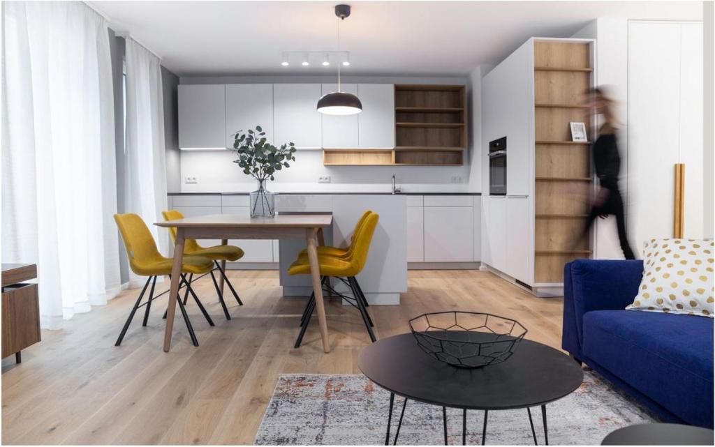 a living room with a table and yellow chairs at The Garden Loft in Frankfurt/Main