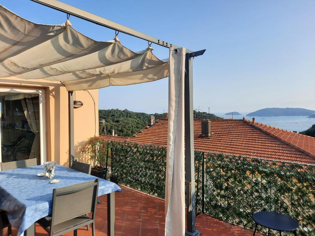 eine Terrasse mit einem Tisch und einem weißen Sonnenschirm in der Unterkunft La Terrazza sul Golfo dei Poeti tra Lerici e le Cinque Terre in Pitelli