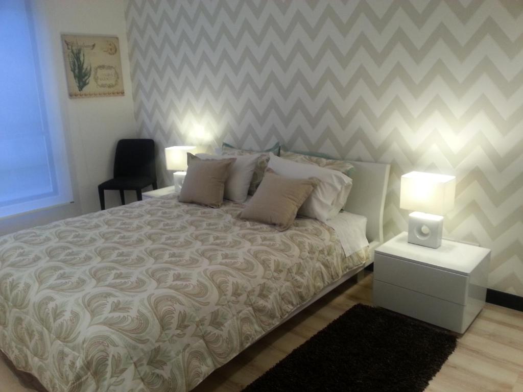 1 dormitorio con 1 cama grande y un chevron en Suites Metropoli Bristol Parc, en Quito