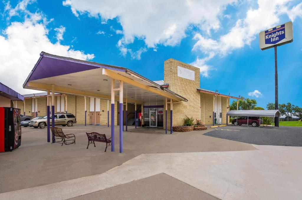 a gas station with a purple awning in a parking lot at Knights Inn Oakley in Oakley