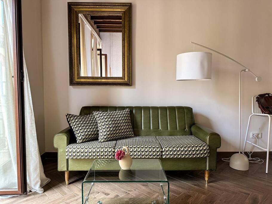 a living room with a green couch and a mirror at CETTI - Centro in Granada