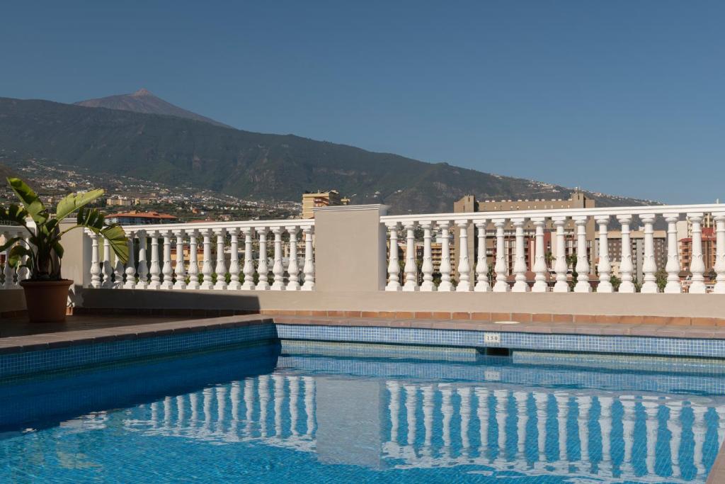 einem Pool vor einem weißen Gebäude in der Unterkunft Hotel Marte in Puerto de la Cruz