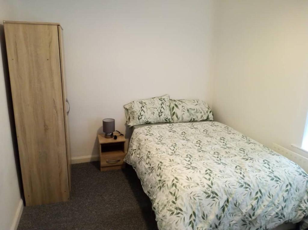a small bedroom with a bed and a night stand at Double-bed (H2) close to Burnley city centre in Burnley