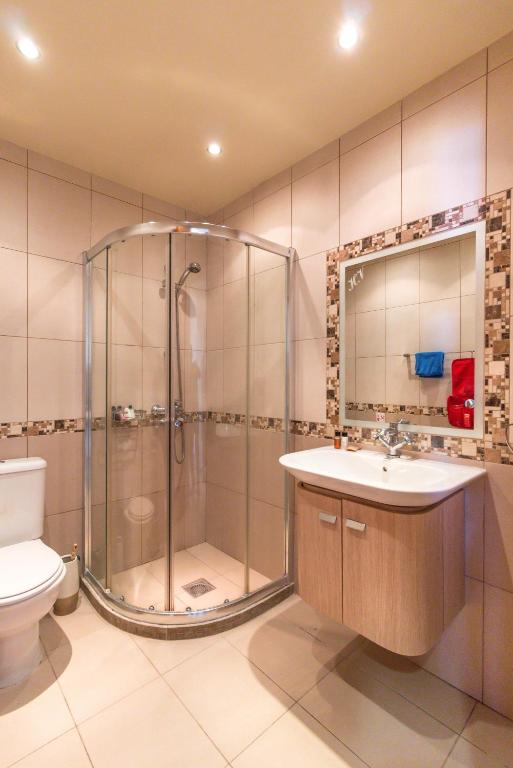a bathroom with a shower and a sink and a toilet at Hill View Hotel Apartments in Pissouri