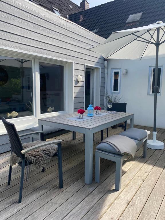 un tavolo e sedie su una terrazza con ombrellone di Deichhaus No.5 a Büsum