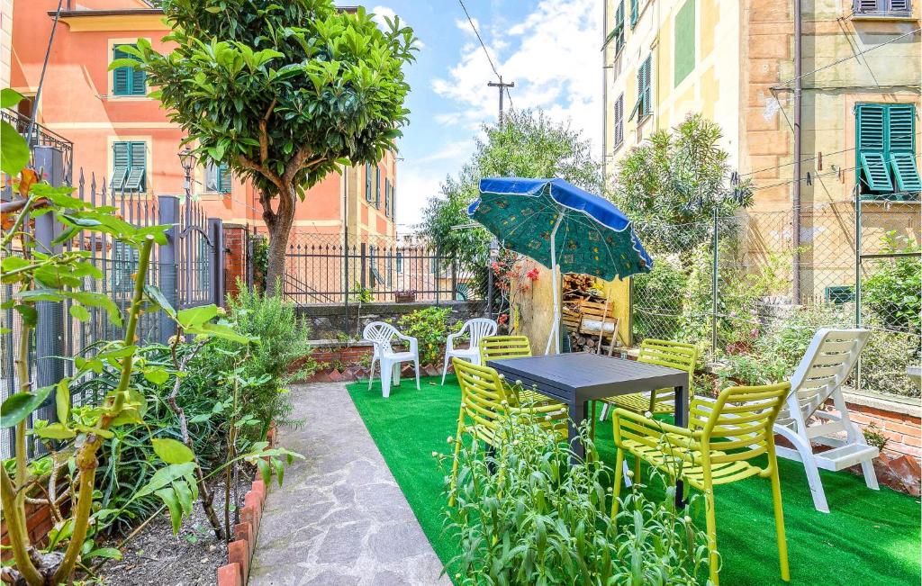 a table with chairs and an umbrella in a garden at Stunning Home In Camogli With Kitchen in Camogli