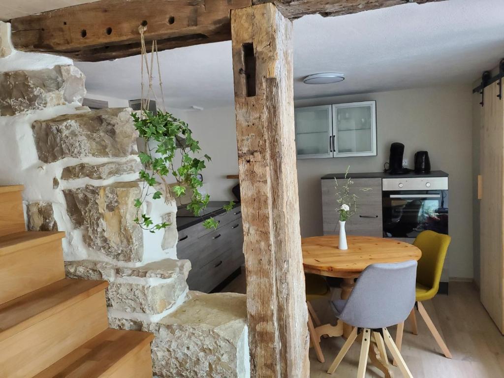 a kitchen and dining room with a stone wall and a wooden table at Donauwelle in Sigmaringendorf