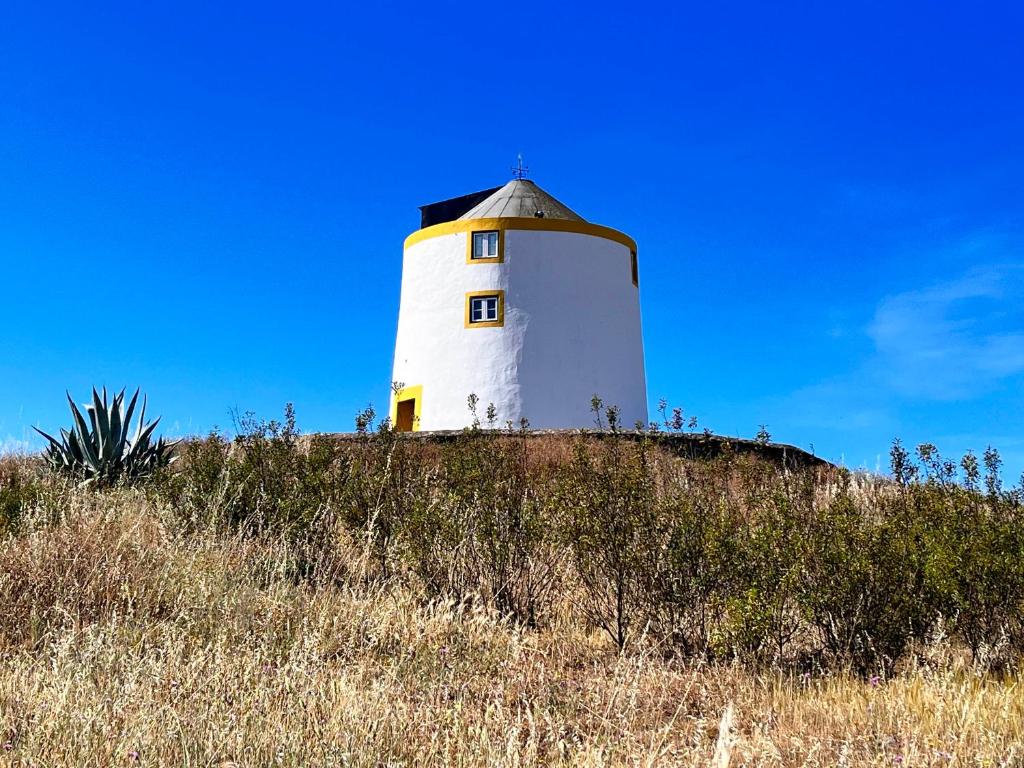 a white lighthouse on top of a hill at Moinho do Monte Branco in Castro Verde