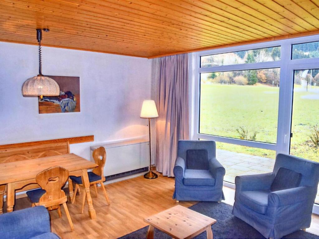 uma sala de estar com uma mesa e cadeiras e uma grande janela em Holiday home Reichenbach em Bayerstetten