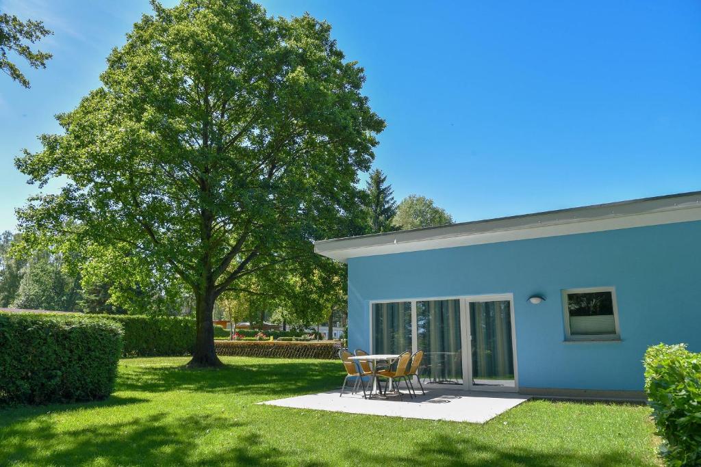una casa blu con tavolo e sedie in cortile di Bungis Am Grimnitzsee a Joachimsthal