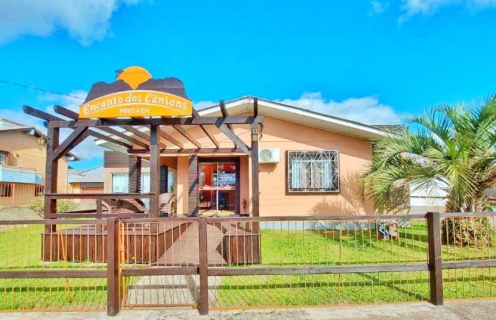 un restaurante con una señal frente a un edificio en Pousada Encanto dos Cânions en Cambara do Sul