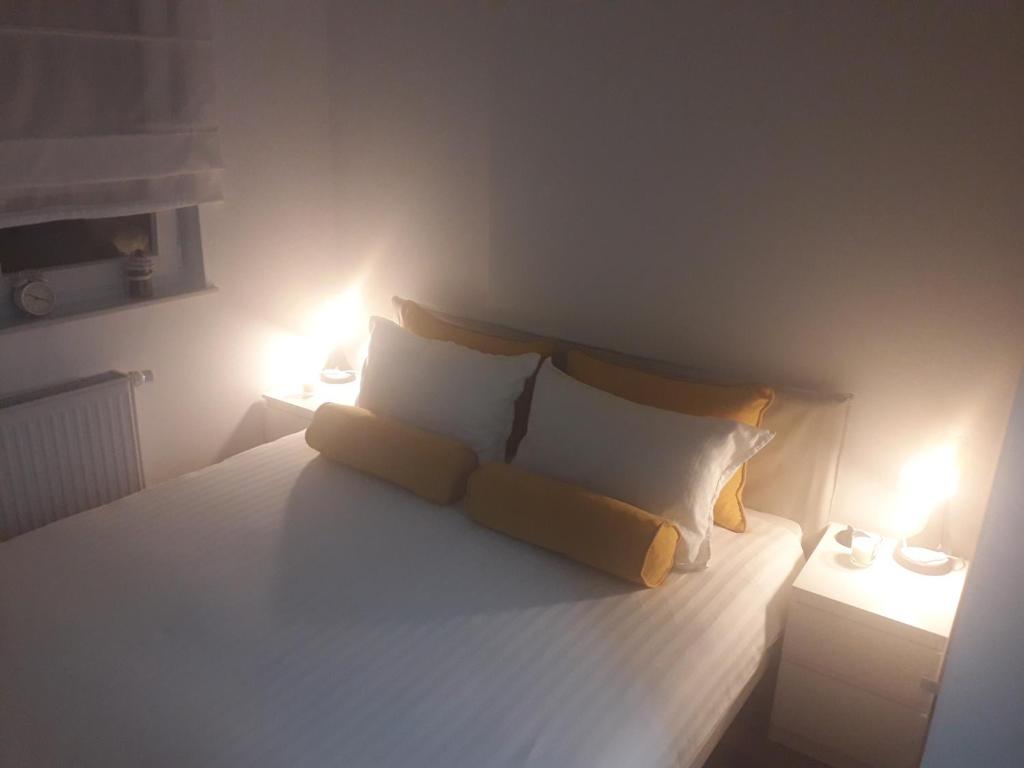 a bedroom with a bed with two lamps on it at Apartmani Kosic in Banja Luka