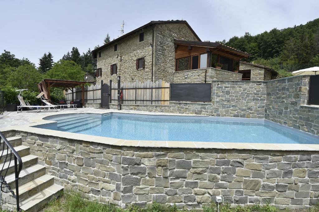 a stone wall around a swimming pool in front of a house at B&B A…Monte in Santa Maria