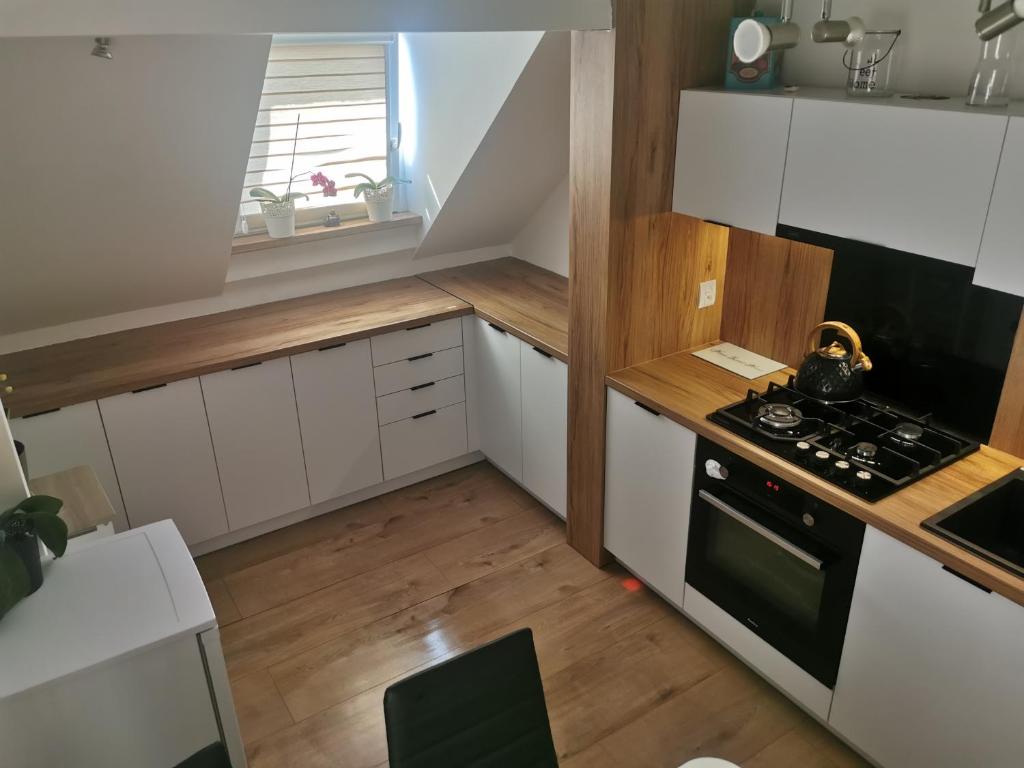 a small kitchen with white cabinets and a stove at Zakątek u Natalii in Lubawka