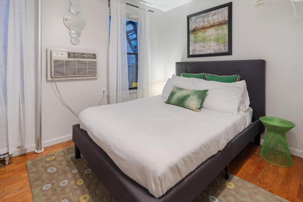 een slaapkamer met een groot bed met een groene kruk bij Elevate Apartment at Times Square - Cozy Studio in Times Square and Nearby Restaurants in New York
