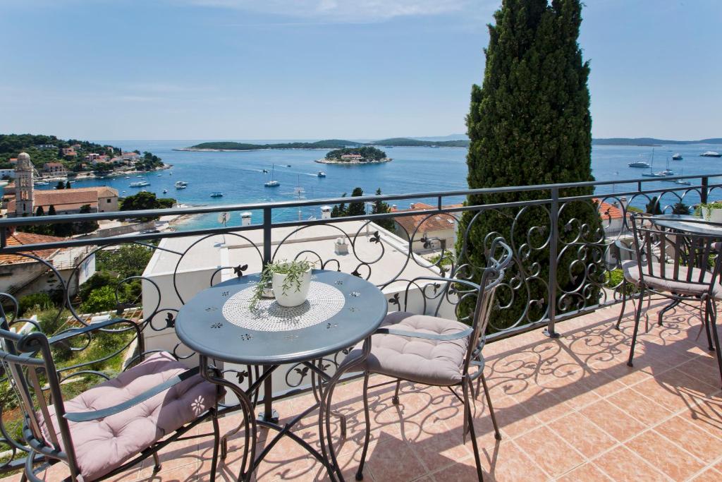 a table and chairs on a balcony with a view of the water at Villa Milton Hvar in Hvar