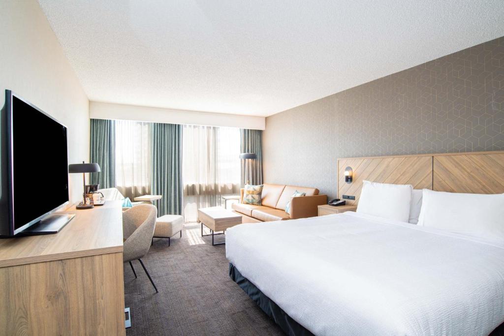 une chambre d'hôtel avec un lit et une télévision dans l'établissement Sandman Hotel Montreal - Longueuil, à Longueuil