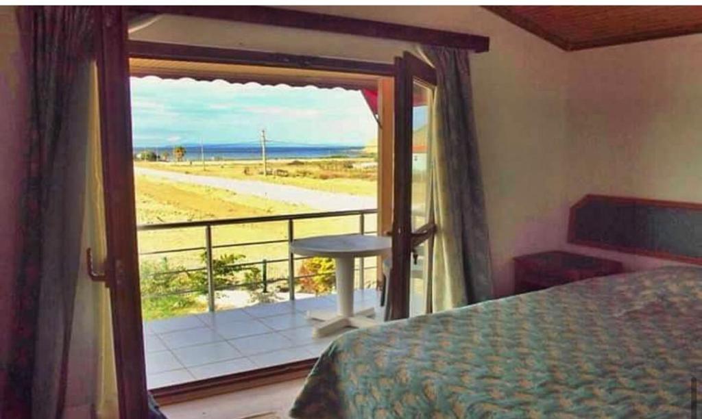 1 dormitorio con cama y vistas a la playa en Sirinevler Apart IMROS, en Gokceada Town
