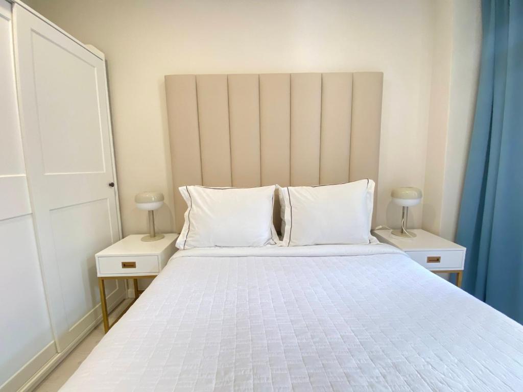 a bedroom with a large white bed with two night stands at Bonneville Setúbal II in Setúbal