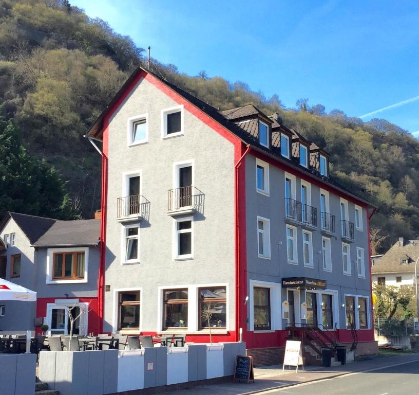 a large building with a mountain in the background at Winzerhaus Gärtner - An der Loreley in Sankt Goar