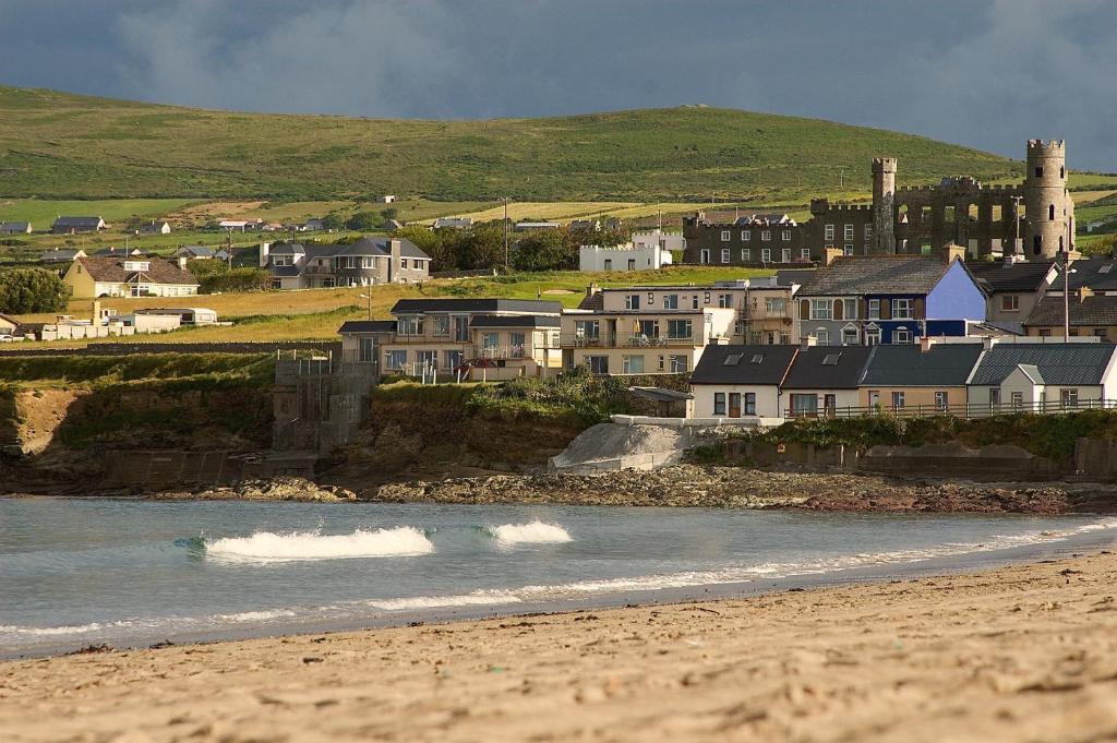 a group of houses on the shore of a beach at ONeills Apartments in Ballyheigue