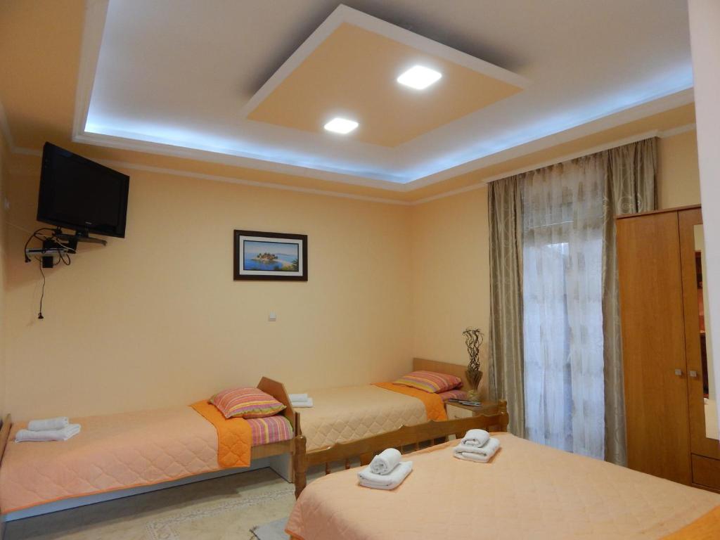 Pokój z 2 łóżkami i telewizorem na suficie w obiekcie Apartments Klakor w mieście Tivat