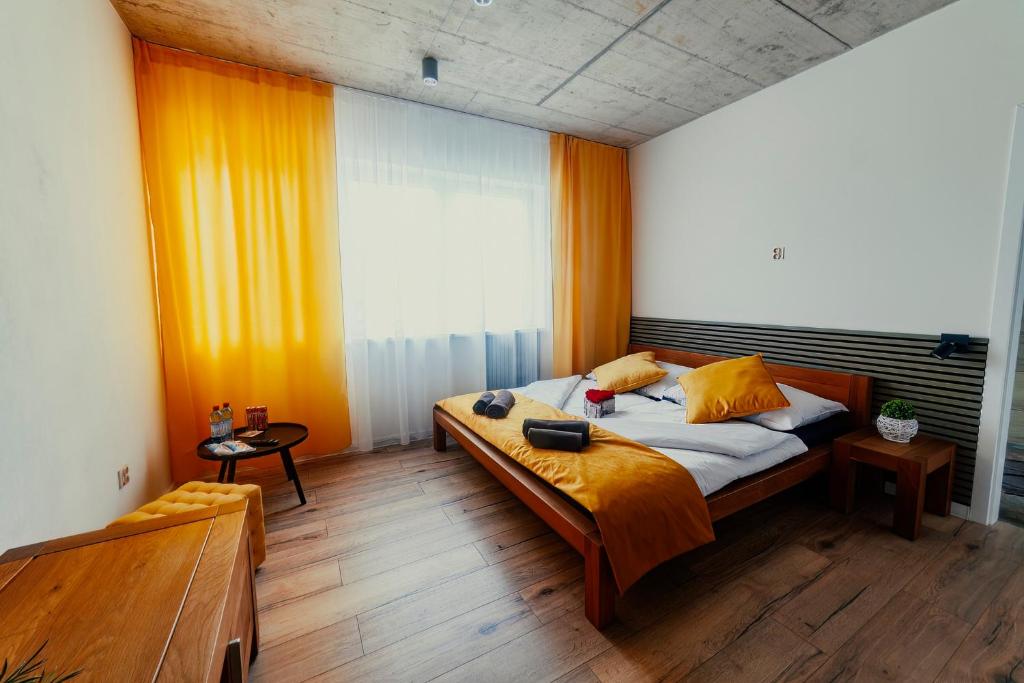 a bedroom with a large bed with orange curtains at Birdhouse in Prešov