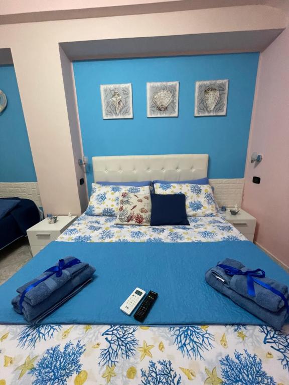 a bedroom with a bed with a remote control on it at Da Santina in Scilla