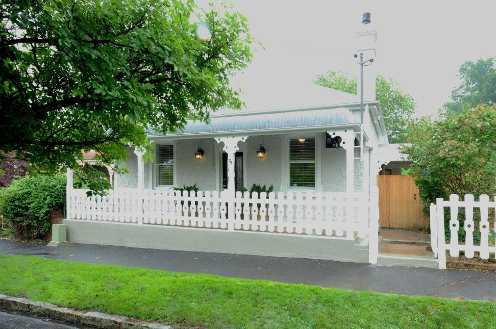 a white picket fence in front of a white house at Cottage 79 in Orange