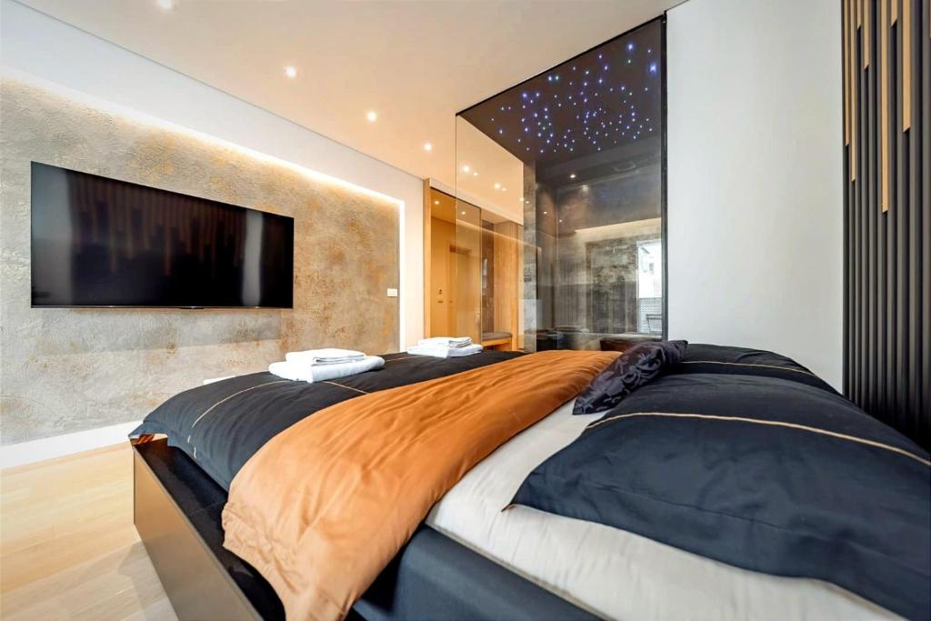 a bedroom with a large bed with a flat screen tv at Kennedy Residence Belgrade in Belgrade