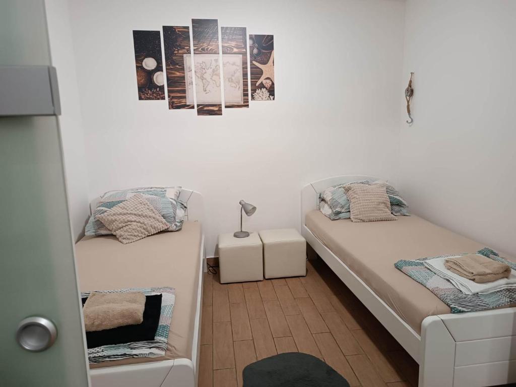 ein kleines Zimmer mit 2 Betten und einer Lampe in der Unterkunft Apartma A&D Koper in Koper
