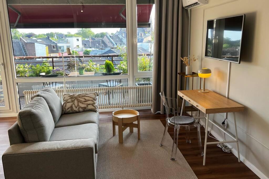 een woonkamer met een bank en een tafel bij BOSTEL 88 - Moderne Stadtwohnung mit Klimaanlage in Moers