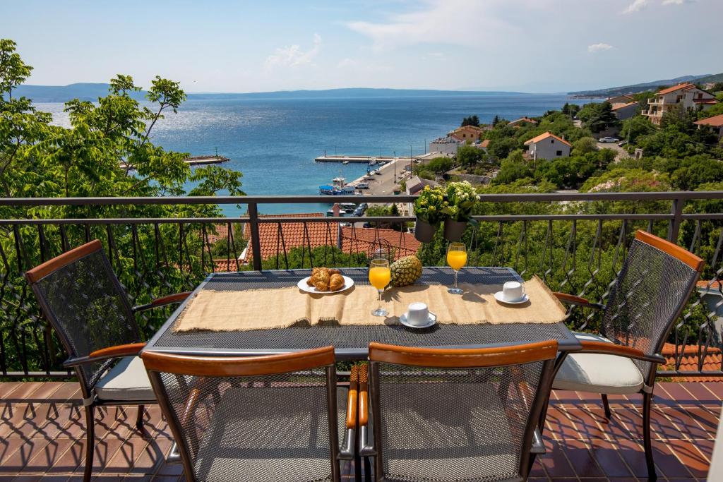 een tafel op een balkon met uitzicht op de oceaan bij Apartments More in Klenovica