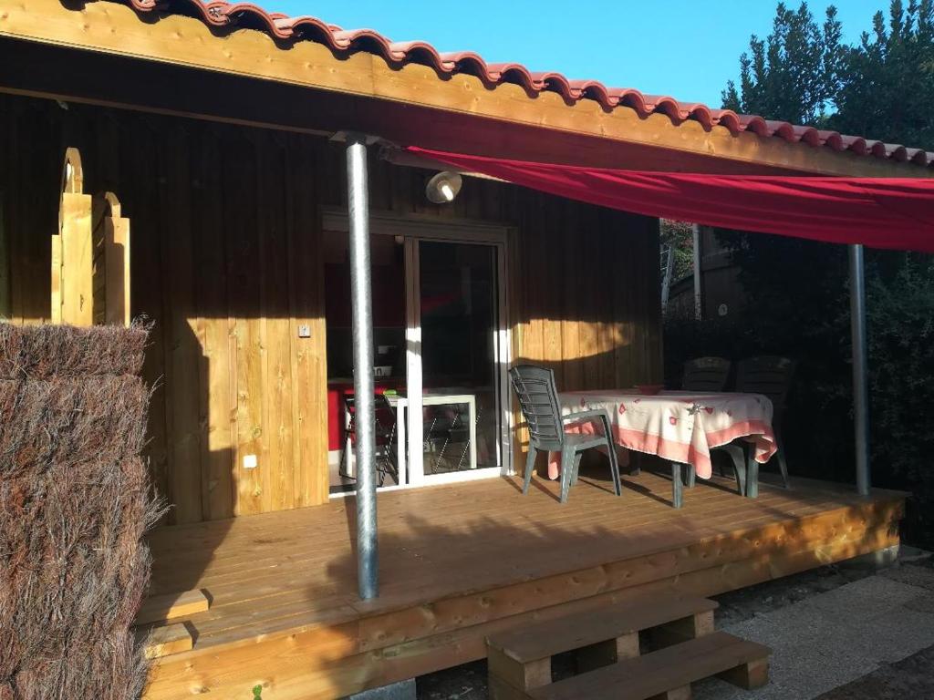 un patio avec une table et des chaises sur une terrasse dans l'établissement La Cabane - Bassin d'Arcachon - Gujan-Mestras, à Gujan-Mestras