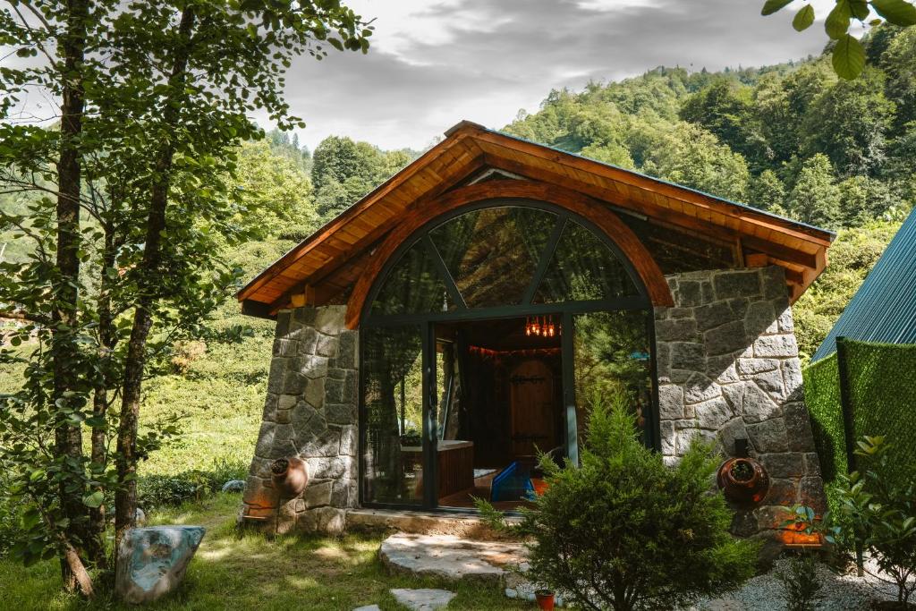 ein kleines Cottage aus Stein inmitten eines Waldes in der Unterkunft Zamane evleri in Çamlıhemşin