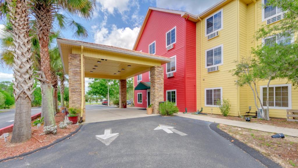 un edificio de color rojo y amarillo en Magnuson Hotel Wildwood Inn Crawfordville, en Crawfordville