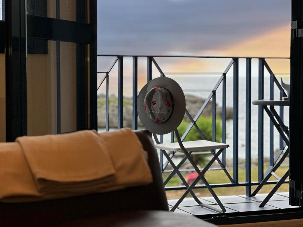 Habitación con balcón con silla y reloj. en La Goleta - 6915, en Noja