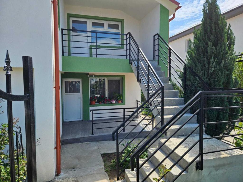 a house with stairs leading up to the front door at Muzicii 11 - Cozy Seaside Apartments in Năvodari
